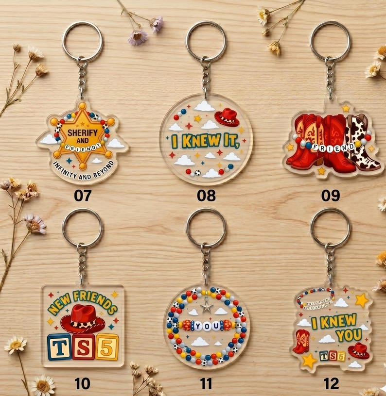 May include: Six clear acrylic keychains featuring colorful designs inspired by western themes. Designs include a sheriff badge, cowboy hats, boots, and lettered beads. Each keychain has a metal ring and chain, labeled with numbers 07 through 12.