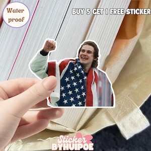 May include: A waterproof sticker featuring a smiling person draped in an American flag. The sticker has a white border and the text "BUY 5 GET 1 FREE STICKER". The sticker is held by a hand. The sticker is from Sticker BYHUIPOE.
