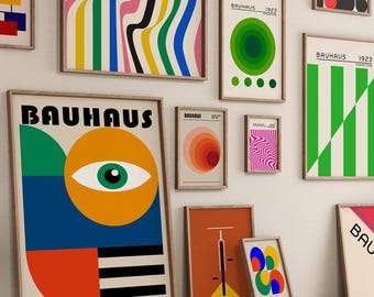 May include: A collection of framed Bauhaus art prints in various sizes and designs. The prints feature geometric shapes, bold colors, and the word "Bauhaus". The artwork is displayed on a white wall, creating a modern and artistic aesthetic.