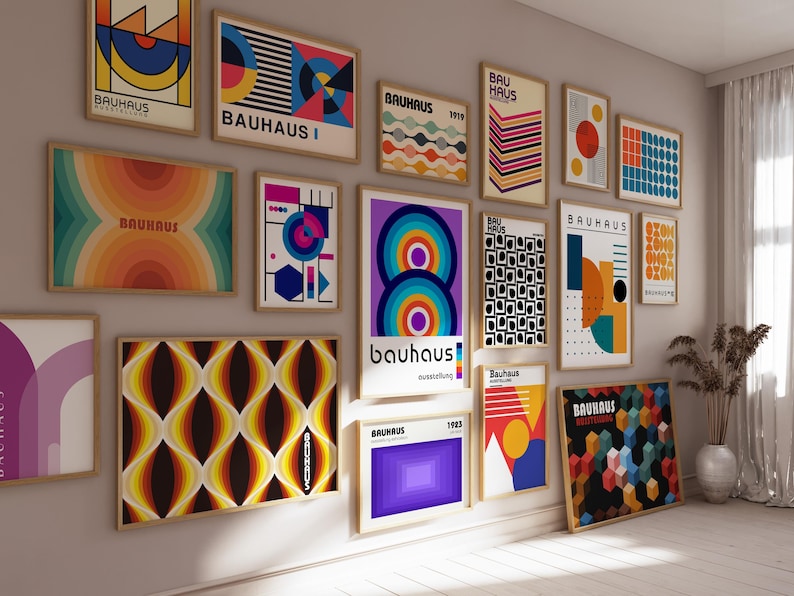 May include: A wall gallery of 14 framed posters with geometric designs in various colors, including red, blue, yellow, orange, green, black, and white. The posters feature the word "Bauhaus" and the year 1919.