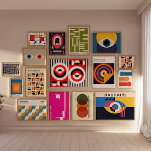 May include: A wall gallery featuring 15 framed prints with geometric designs in various colors, including red, yellow, blue, black, and white. The prints feature the word "Bauhaus" and the year "1919".