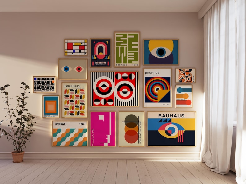 May include: A wall gallery featuring 15 framed prints with geometric designs in various colors, including red, yellow, blue, black, and white. The prints feature the word "Bauhaus" and the year "1919".