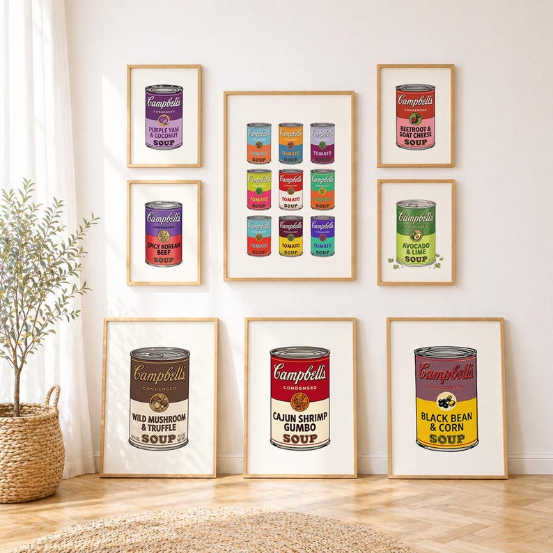 May include: A gallery wall arrangement of eight framed prints featuring various Campbell's soup cans. The prints display colorful labels with text including Purple Yam & Coconut, Spicy Korean Beef, Beetroot & Goat Cheese, Avocado & Lime, Wild Mushroom & Truffle, Cajun Shrimp Gumbo, and Black Bean & Corn.