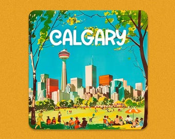 May include: A square coaster featuring a vintage illustration of Calgary, Canada. The image depicts the city skyline with the Calgary Tower, trees, and people in a park. The word "CALGARY" is written in white script across the top.