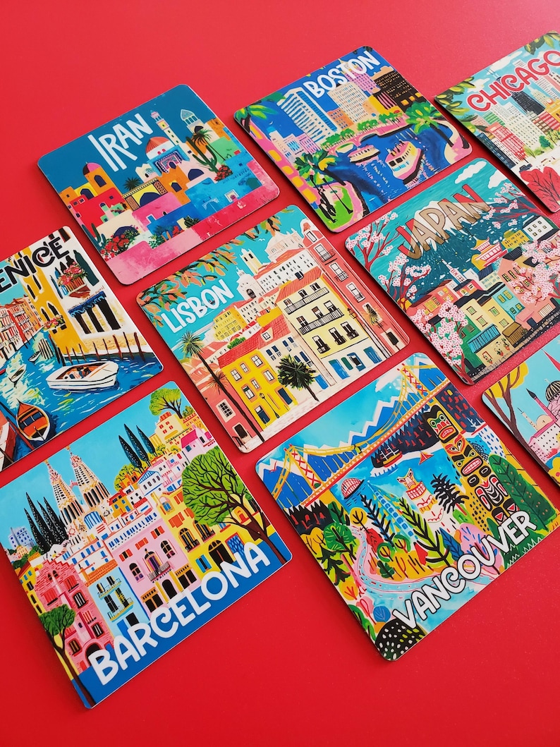 Op de afbeelding: Een verzameling kleurrijke vierkante onderzetters met stadsgezichten. Elke onderzetter toont een andere stad, waaronder Boston, Chicago en Barcelona, met levendige illustraties en stadsnamen. De onderzetters zijn gerangschikt op een rode ondergrond.