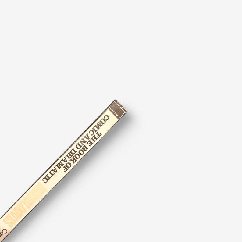 May include: Close-up of the spine of a book titled "The Book of Comic and Dramatic Stories".