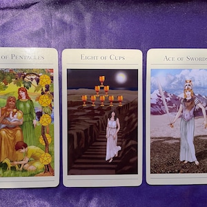 May include: Three tarot cards, Ten of Pentacles, Eight of Cups, and Ace of Swords. The Ten of Pentacles card shows a family with a pentagram design around them. The Eight of Cups card shows a woman walking away from a row of cups. The Ace of Swords card shows a woman holding a sword.