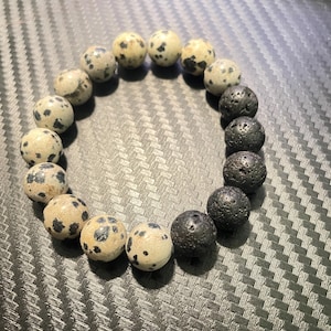 May include: A bracelet made of black lava rock and white dalmatian jasper beads.