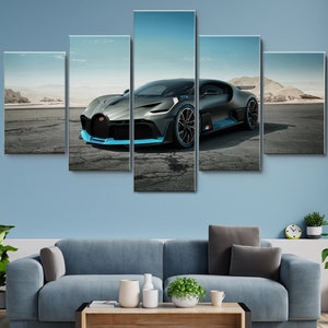 May include: A black and blue Bugatti Chiron supercar is parked on a cracked tarmac road in a desert landscape. The car has a blue stripe running along the side and a blue accent on the front bumper.