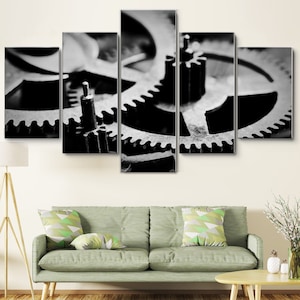 Puede incluir: Primer plano en blanco y negro de un conjunto de engranajes interconectados. Los engranajes son de metal y tienen un aspecto desgastado e industrial.