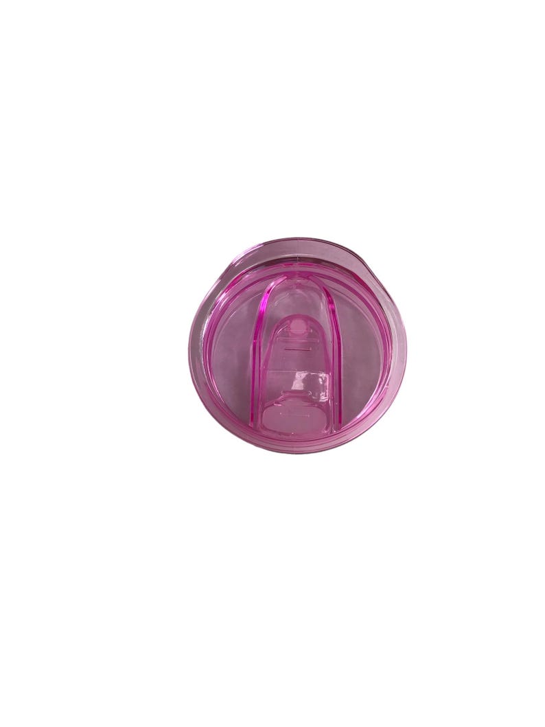Op de afbeelding: Een helder, roze plastic tumblerdeksel met een schuifsluiting. Het deksel is cirkelvormig met een verhoogd middengedeelte en een kleine opening om uit te drinken. Het plastic is doorschijnend.