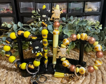 Conjunto de pulseiras e caneta combinando com estampa de vaca das Terras Altas