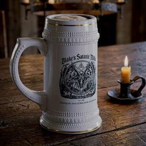 Op de afbeelding: Een witte keramische bierpul met een gouden rand en een textuur met kralenpatroon. De voorzijde toont een zwarte afbeelding van een geitenkop in een pentagram met de tekst Blake's Satanic Mills en Grinding the Souls of Man for the Greater Good.