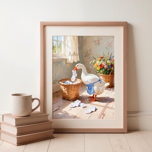 May include: A framed print featuring a white goose wearing a blue and white striped apron, holding a white sock in its beak near a wicker laundry basket. Three white socks lie on the wooden floor, with a bouquet of colorful flowers nearby.