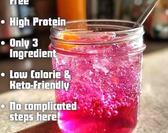 May include: A mason jar filled with a vibrant pink beverage, ice, and a slice of orange. The text on the left side of the image reads: "100% Sugar-Free", "High Protein", "Only 3 Ingredient", "Low Calorie & Keto-Friendly", and "No complicated steps here!"