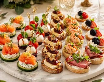 May include: A variety of appetizers arranged on a round marble platter, including cucumber slices topped with smoked salmon, skewers with cherry tomatoes and mozzarella, toasted bread with brie and jam, shrimp on avocado, and roast beef crostini.