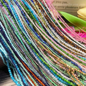 May include: A vibrant assortment of beaded necklaces in shades of blue, green, pink, and brown. The small beads are strung together, forming a textured, colourful display. These necklaces are likely intended for jewellery making or crafting projects.