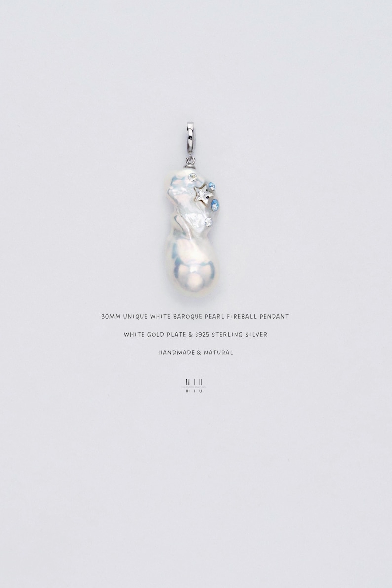 Op de afbeelding: Een unieke witte barokke parel hanger met een vuurbal ontwerp. De hanger heeft een witgouden plaat en S925 sterling zilver. De tekst op de afbeelding luidt "30MM UNIQUE WHITE BAROQUE PEARL FIREBALL PENDANT" en "HANDMADE & NATURAL."