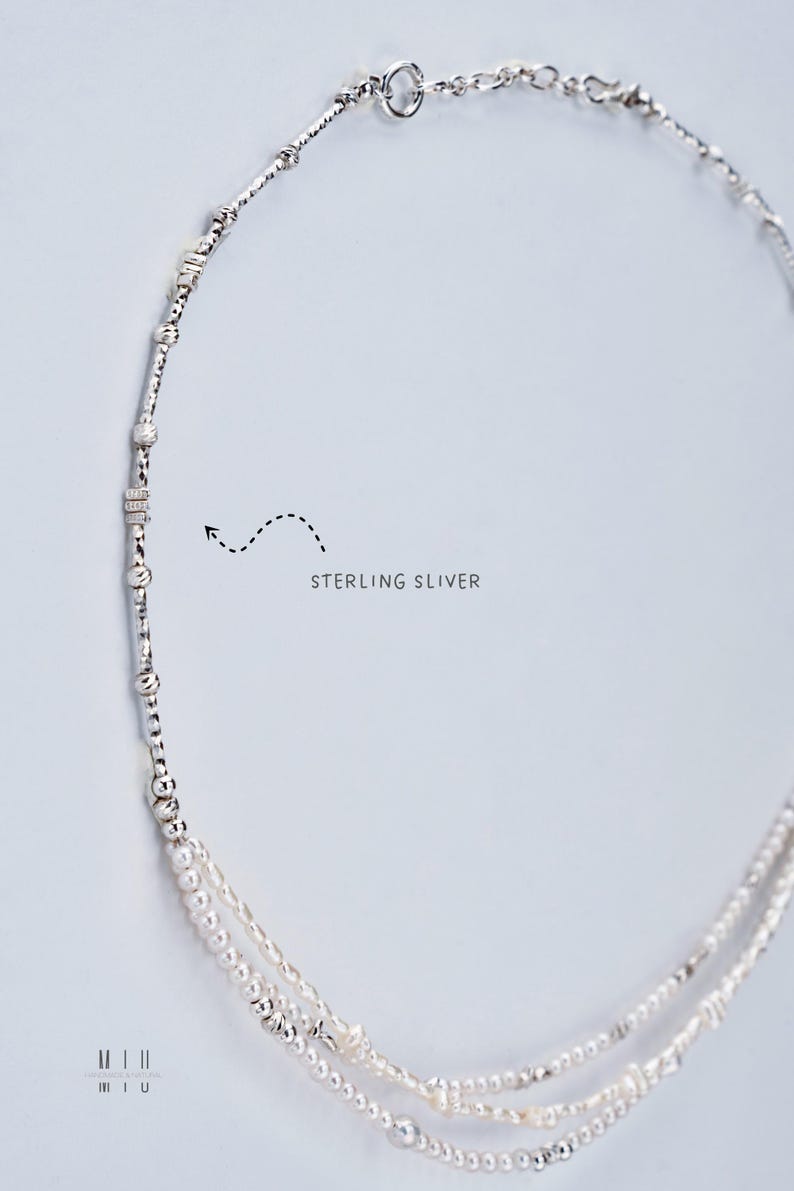 K&ouml;nnte beinhalten: Eine zarte Halskette aus Sterlingsilber mit mehreren Str&auml;ngen. Die Halskette hat kleine, runde Perlen und strukturierte Silberelemente. Der Text "STERLING SILVER" ist im Bild sichtbar. Die Halskette wird vor einem hellen Hintergrund pr&auml;sentiert.