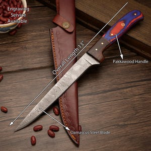 Könnte beinhalten: Ein Messer mit Damaststahlklinge und Pakkawood-Griff. Die Gesamtlänge beträgt 33 cm. Das Messer befindet sich in einer braunen Lederscheide. Der Griff hat rote und blaue Akzente. Gravur verfügbar.