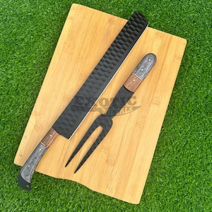 May include: A black knife and fork set with wooden handles on a bamboo cutting board. The knife has a textured blade and the fork has a decorative design.