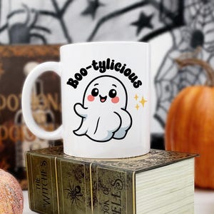 Peut inclure: Mug en céramique blanche avec une anse noire, portant l'inscription "But First, Coffee" en noir. Le mug est présenté sur un fond flou, suggérant un cadre chaleureux.