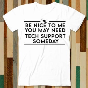 Puede incluir: Camiseta blanca con texto negro que dice "Sé amable conmigo, es posible que necesites soporte técnico algún día". Un icono de cursor de ratón negro está sobre el texto.