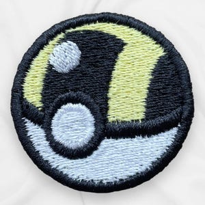 May include: Embroidered patch featuring a black, white, and yellow design. The patch is circular, with a black background and a white and yellow design. The design includes a white circle and a yellow curved shape. The patch has a black border.