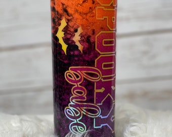 May include: A black, orange, and purple glitter tumbler with the text "Spooky" in gold glitter. Two bats are visible in the orange glitter section of the tumbler.