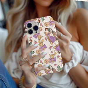 May include: A white phone case with a repeating pattern of cartoon characters from the Disney movie Tangled. The characters include Rapunzel, Flynn Rider, and Pascal the chameleon. The case has a clear camera lens cutout.