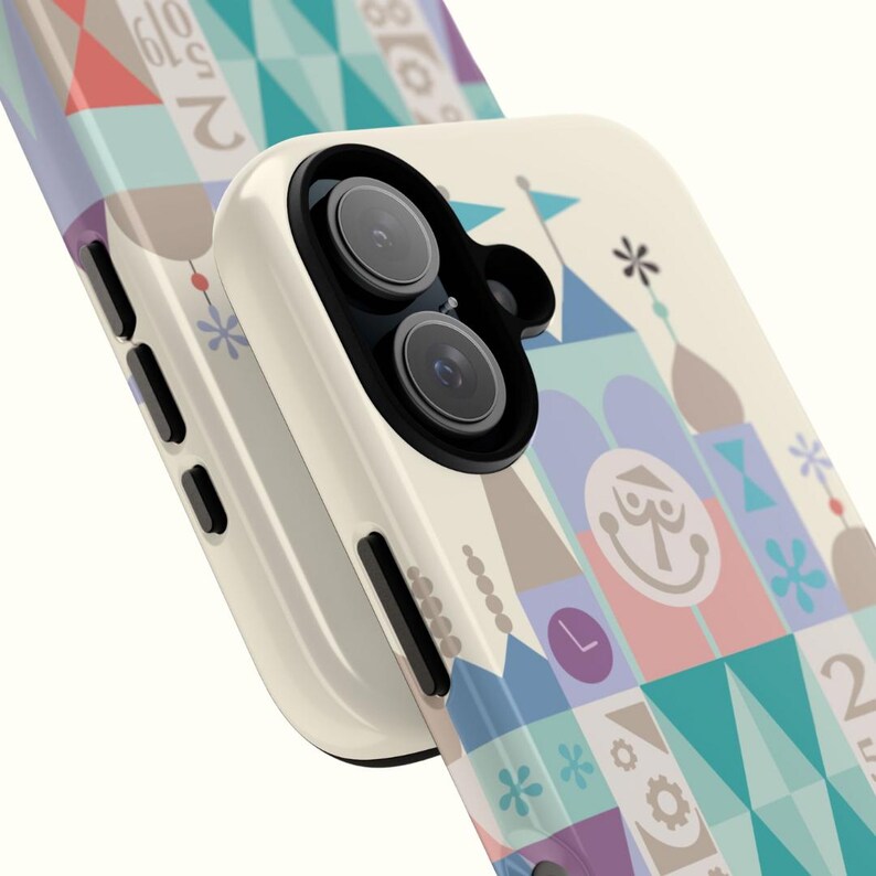 Puede incluir: Una funda de tel&eacute;fono blanca con un dise&ntilde;o geom&eacute;trico colorido que presenta un castillo de dibujos animados y el texto "25 Years of Magic".