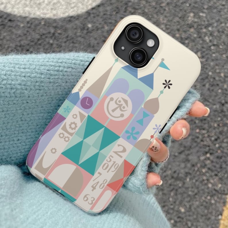 Puede incluir: Una funda blanca para iPhone con un dise&ntilde;o geom&eacute;trico colorido que presenta una cara de dibujos animados y los n&uacute;meros 2, 5, 0, 1, 9, 7, 4, 8, 6 y 3.