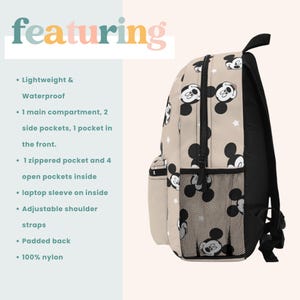 Puede incluir: Una mochila beige con una cremallera negra y correas negras. La mochila tiene un patr&oacute;n repetido de cabezas de Mickey Mouse y estrellas blancas. La mochila tiene un bolsillo de malla en el lateral y un bolsillo con cremallera en la parte delantera. El texto "featuring" est&aacute; en la esquina superior izquierda de la imagen.