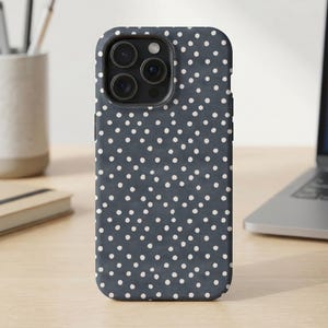 May include: A dark charcoal grey smartphone case featuring a repeating pattern of small, irregular white polka dots across the entire back surface, including a cutout for the triple-lens camera system located in the upper left corner.