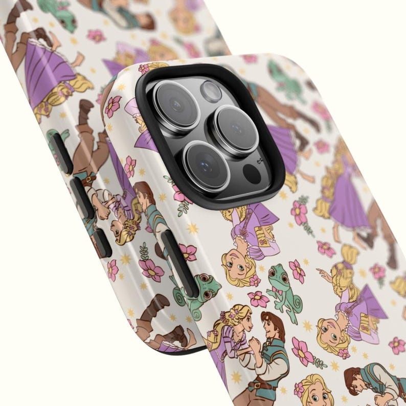 May include: A white phone case with a pattern of Rapunzel and Flynn Rider from the Disney movie Tangled. The case has a black camera bump with three lenses.