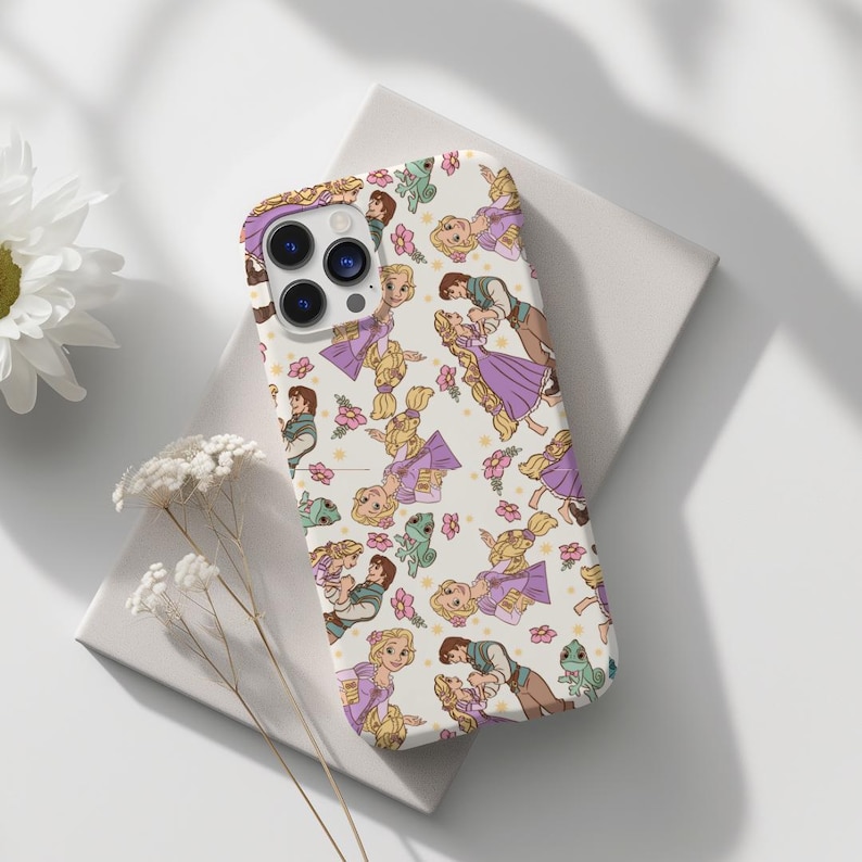 May include: A white phone case with a repeating pattern of Rapunzel and Flynn Rider from the Disney movie Tangled. The characters are depicted in a cartoon style with purple and yellow accents.