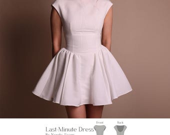 Puede incluir: Un vestido blanco con un corpiño ajustado y una falda acampanada. El vestido tiene un escote barco y mangas cortas. El texto "Last-Minute Dress" es visible, junto con el nombre del diseñador y el nivel de dificultad. El vestido lo lleva una persona.