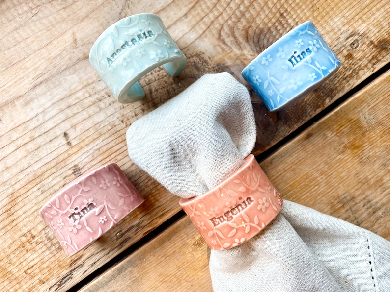 May include: Four ceramic napkin rings with floral designs and personalized names: "Anastasia", "Ilina", "Tina", and "Eugenia".