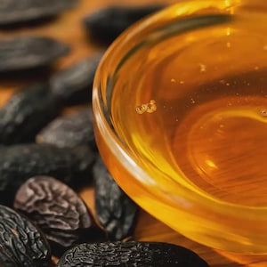 May include: A white ceramic mug with a black handle and the text "But First, Coffee" in a bold, black font. The mug is set against a blurred background, suggesting a cozy setting.