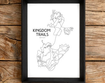 May include: A black framed print with a line drawing map of the Kingdom Trails in Vermont. The text "KINGDOM TRAILS Vermont" is printed below the map.