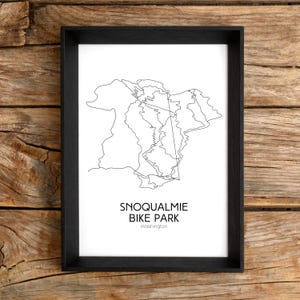 Pode incluir: Uma impressão emoldurada em preto e branco. A obra de arte retrata um mapa do Snoqualmie Bike Park em Washington. O texto "SNOQUALMIE BIKE PARK Washington" é impresso abaixo.