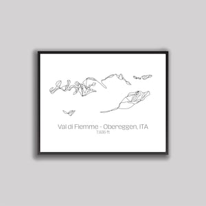 May include: A framed black and white print featuring a minimalist line drawing of a mountain range. The text "Val di Fiemme - Obereggen, ITA" is printed below the drawing, along with the elevation of 7,835 ft.