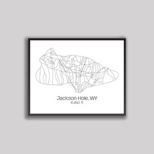 May include: Black framed print featuring a minimalist line drawing of the Jackson Hole, WY ski resort. The artwork includes the resort's name and elevation, 10,450 ft, in a simple, modern font. The design is set against a white background.