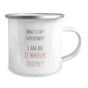 May include: White enamel mug with a silver rim and a black and brown text design that reads "What is my superpower? I am an 18 wheeler driver!!"