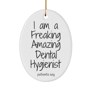 May include: White ceramic Christmas bauble with black text that reads "I am a Freaking Amazing Dental Hygienist patients say".