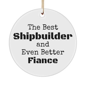 May include: White ceramic Christmas ornament with black text that reads "The Best Shipbuilder and Even Better Fiance".