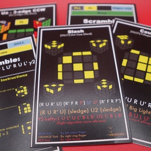 May include: Close-up of five black cards with yellow and white squares on them. The cards are labeled with the words "Scramble", "Slash", "Couch", "Big Lightning", and "Y2-Lefty". Each card has a different pattern of squares and a set of instructions for solving a Rubik's Cube.