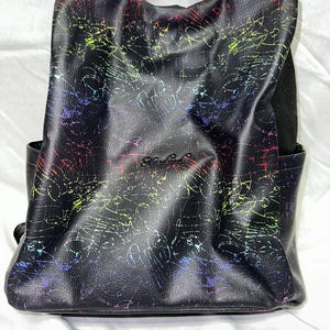 May include: Black leather backpack with a rainbow-colored scribble pattern and the word "Handmade" in black lettering.