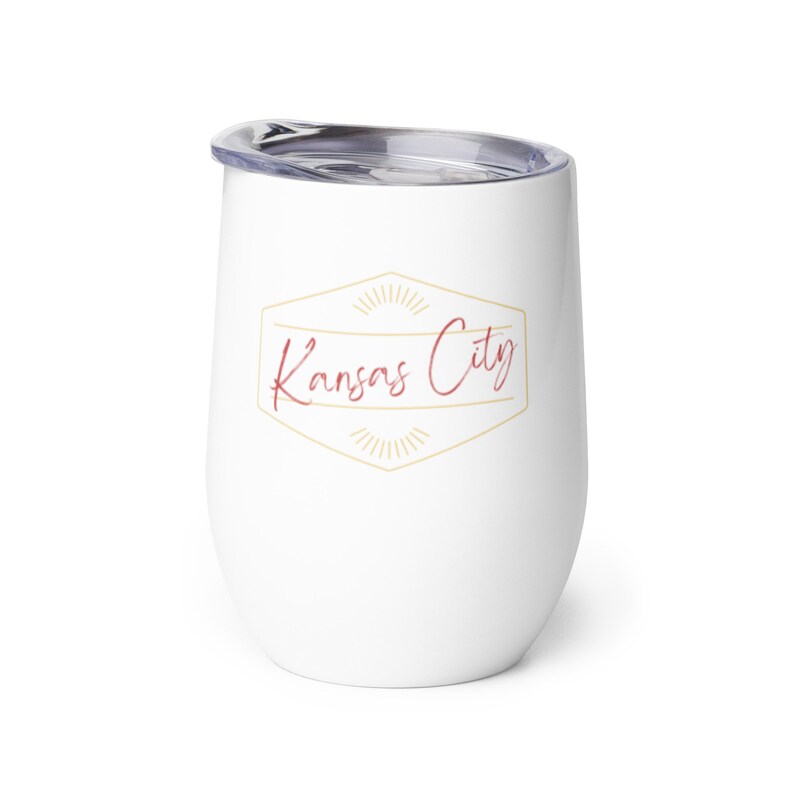 May include: White stainless steel tumbler with a gold and red logo that says "Kansas City" in a script font.
