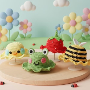 May include: A collection of handmade crochet hats in the shape of a duck, frog, strawberry, and bee. The hats are yellow, green, red, and black with white and pink accents. The hats are displayed on small stands against a whimsical backdrop of flowers and clouds.